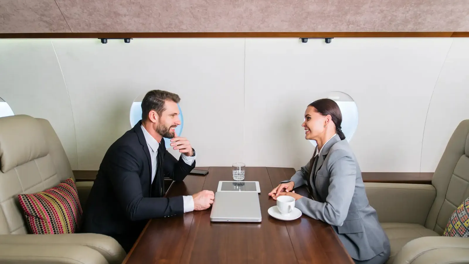 Two executives in a meeting at the conference table of a private jet cabin