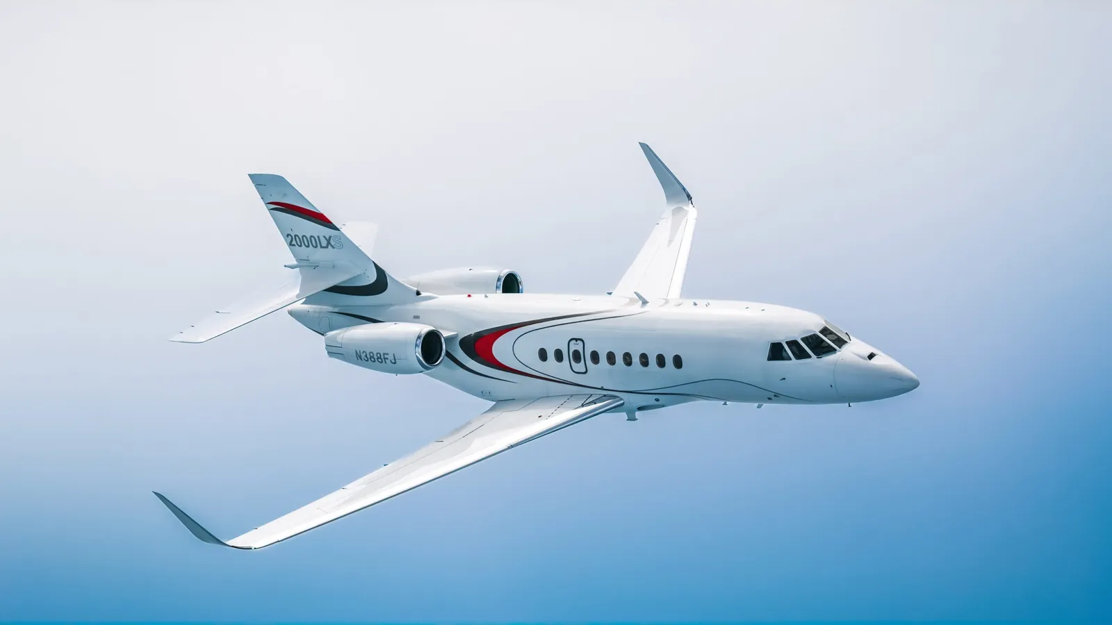 Dassault Falcon 2000LXS business jet in flight against a pale blue sky