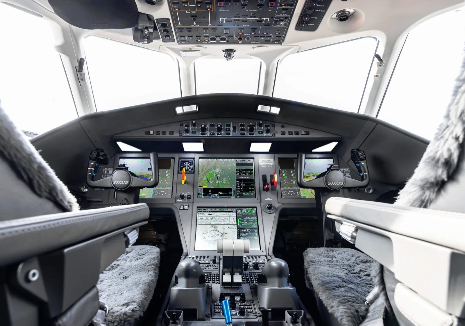 Flight deck of the Dassault Falcon 2000LXS with its large displays, seen from the cabin